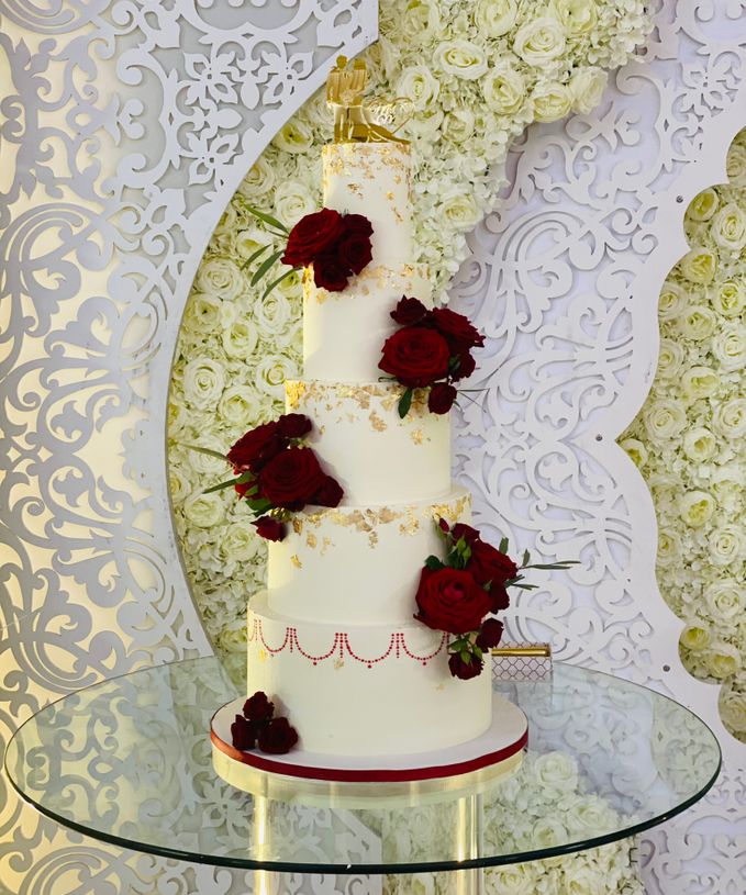 Wit - goud en rode bruidstaart verse bloemen